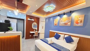 A modern hotel room with a bed, desk, and vanity. - New Condotel-Inspired Studio with
Hot & Cold Shower, 10 minutes SM Mall (General Santos City (Dadiangas))