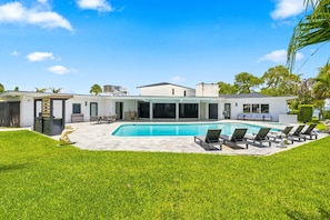A modern house with a swimming pool, outdoor seating, and a well-maintained lawn. - McCarty Mansion - Fort Pierce Waterfront Paradise - 7Br/6Ba - Sleeps 20 (Fort Pierce)