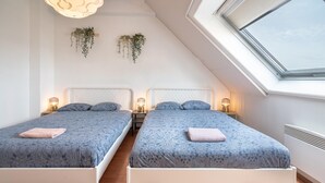 A bedroom with two beds, a skylight, and hanging plants. - 2 Bedroom Apartment in Antwerp (Antwerp)