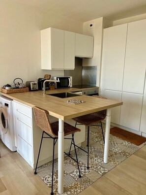 A compact kitchen with a central island, a washing machine, and a microwave. - Seaside cocoon renovated top floor 180-degree view. Air conditioning and private parking. (Ajaccio)