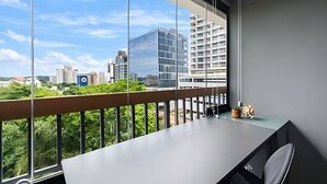 A modern room with a large window, a desk, and a chair. - Uwin 403 - Apartment 10 minutes from Chucri Zaidan (São Paulo)