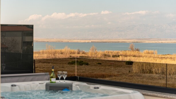 Uma banheira de hidromassagem com vista para um lago e montanhas.