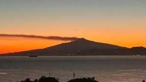 A sunset view with a mountain silhouette and calm water. - Civico 2o la casa di nina (Reggio Calabria)