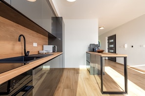 A modern kitchen with a wooden countertop, black faucet, and a glass backsplash. - Seaview Villa Sal with pool, jacuzzi and sauna (Privlaka)