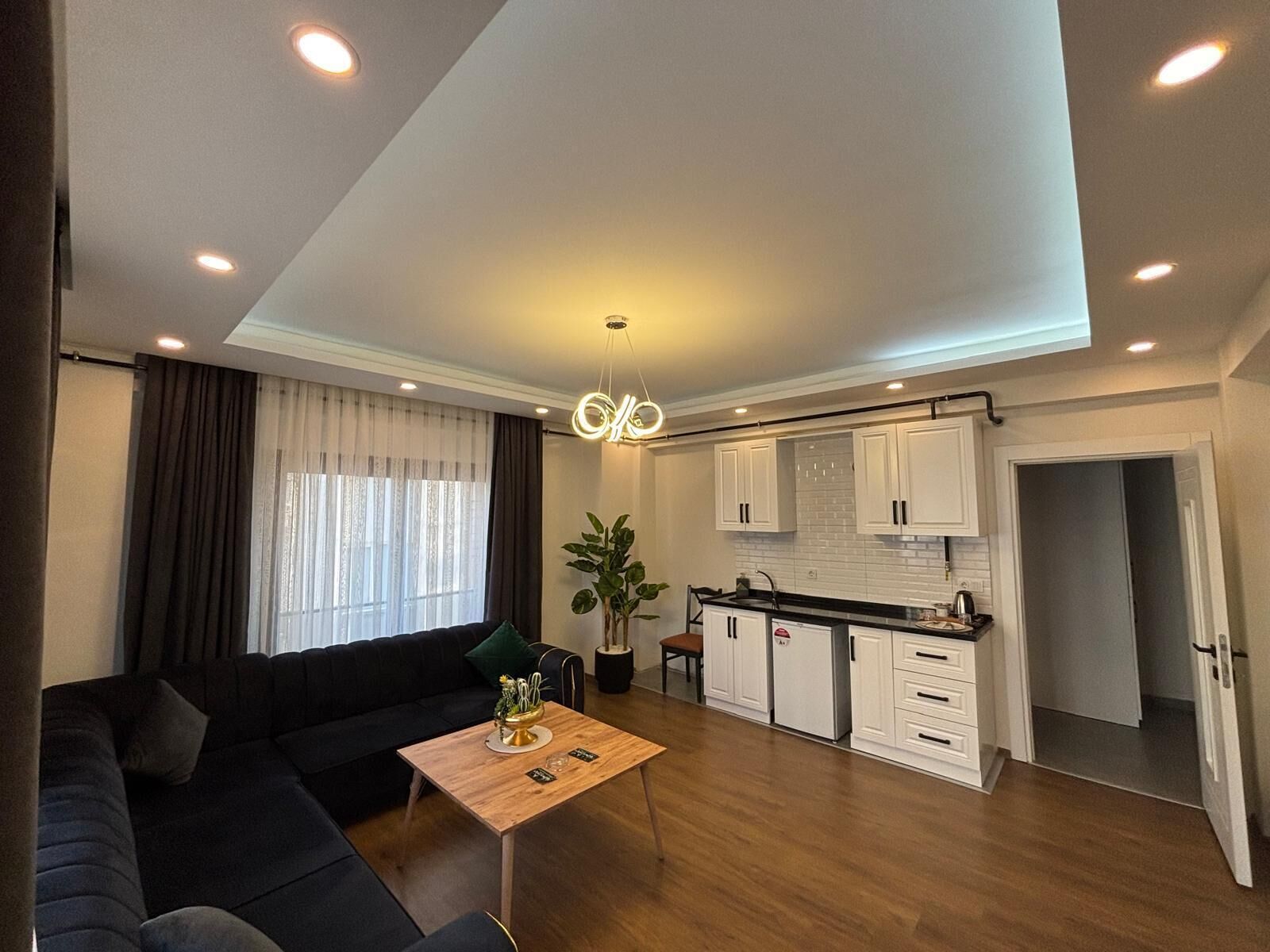 Een modern appartement met een woonkamer, een eethoek en een keuken.