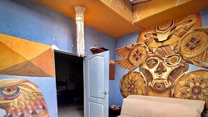 A room with a sofa, a door, and a wall with a geometric pattern. - Hostalito Lahar (Bacalar)