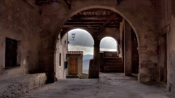 An arched corridor with a wooden door and a view through the arches. - Apartment 'La Casa Di Falstaff' with Mountain View, Balcony and Wi-Fi (Santa Fiora)