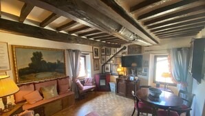 A cozy room with a wooden ceiling, a sofa, a table, and chairs. - Apartment 'La Casa Di Falstaff' with Mountain View, Balcony and Wi-Fi (Santa Fiora)