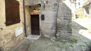 A stone building with a dark wooden door, a small window with shutters, and a mailbox on the wall. - Apartment 'La Casa Di Falstaff' with Mountain View, Balcony and Wi-Fi (Santa Fiora)