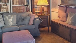 A cozy room with a wooden ceiling, a bookshelf, a lamp, and a painting. - Apartment 'La Casa Di Falstaff' with Mountain View, Balcony and Wi-Fi (Santa Fiora)