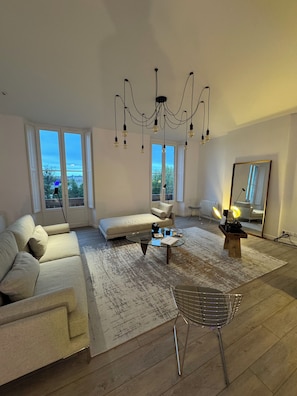 Ein modernes Wohnzimmer mit Sofa, Couchtisch und einer Chandelier.
