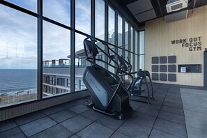 A gym with large windows, a treadmill, and a wall with 'WORK OUT FOCUS GYM' text.