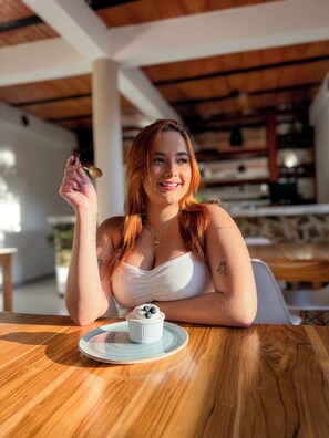 A person seated at a wooden table with a dessert in front of them. - Horizonte del Mar Hotel Boutique  (Santa Marta)