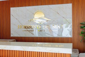 A reception desk with a sign that reads 'HORIZONTE DEL MAR HOTEL BOUTIQUE'. - Horizonte del Mar Hotel Boutique  (Santa Marta)