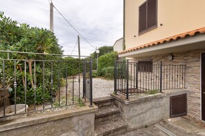 Il s’agit d’une propriété résidentielle dotée d’une entrée sécurisée par un portail, d’un escalier en pierre et d’un bâtiment dont le toit est recouvert de tuiles.