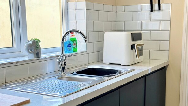 A kitchen with a stainless steel sink, a white toaster, and a window with a view. - South Shields Coastal House Near Beaches- South (South Shields)