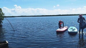 Een rustig meer met paddleboards en reddingsvesten.