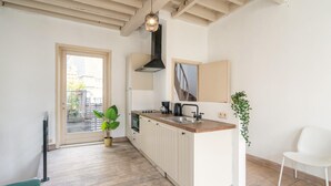Una cucina moderna con pavimento in legno, un'isola centrale, forno integrato e un'ampia finestra.