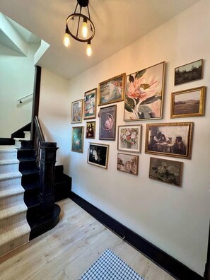A staircase with a black handrail and a light wooden floor. - Family Loft walk2 Downtown Fun (Omaha)