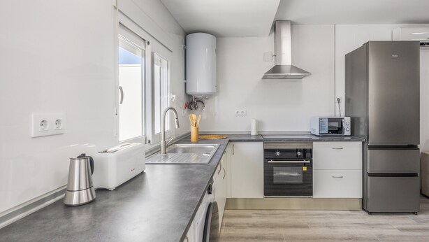 A modern kitchen with a built-in oven, microwave, and stainless steel refrigerator. - Holiday Home 'Kaki 5' with Private Pool, Wi-Fi and Air Conditioning (Barrio Nuevo)