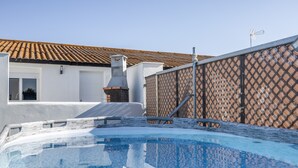 A swimming pool with a tiled roof and a chimney, surrounded by a fence and a building with a tiled roof. - Holiday Home 'Kaki 5' with Private Pool, Wi-Fi and Air Conditioning (Barrio Nuevo)