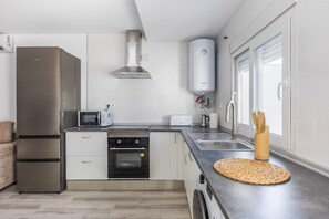 A modern kitchen with a stainless steel refrigerator, microwave, oven, and a water heater. - Holiday Home 'Villa Kaki 4' with Private Pool, Wi-Fi and Air Conditioning (Barrio Nuevo)