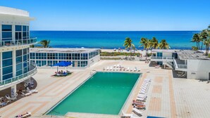 Um resort com piscina, praia e palmeiras.