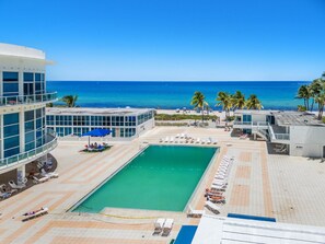 A resort with a swimming pool, beach, and palm trees. - 1701 - Studio Ocean Front Free Parking Pool 4 pers (Miami Beach)