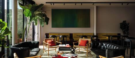 A modern interior with a sofa, chairs, a coffee table, and a large abstract painting on the wall.