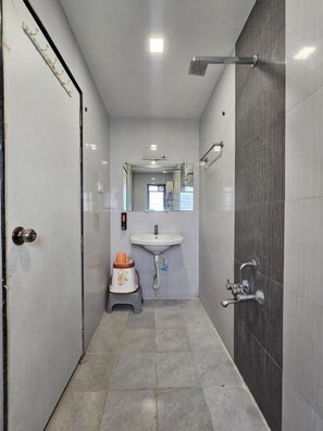 Un banyet petit amb un lavabo, un mirall i una dutxa.