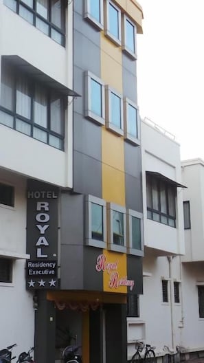 A multi-story building with a sign indicating it is a hotel. - Hotel Royal Residency Executive  (Miraj)