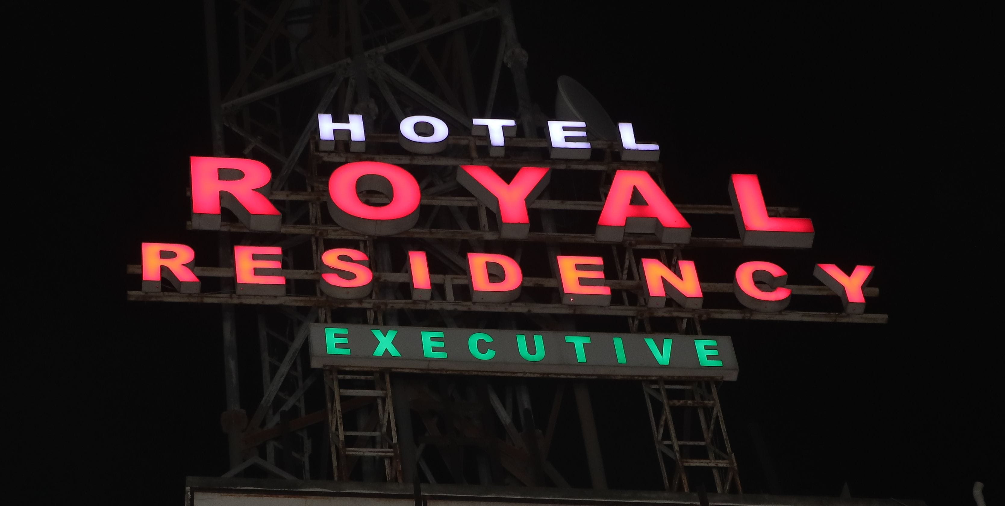 Une enseigne pour l’hôtel Royal Residency, avec le mot « EXECUTIVE » inscrit en dessous du nom principal.