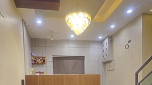 A reception area with a reception desk, a sofa, a chandelier, and a staircase. - Hotel Royal Residency Executive  (Sangli Miraj Kupwad)