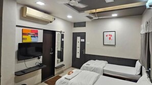 A hotel room with two beds, a flat-screen TV, an air conditioning unit, and a ceiling fan. - Hotel Royal Residency Executive  (Sangli Miraj Kupwad)