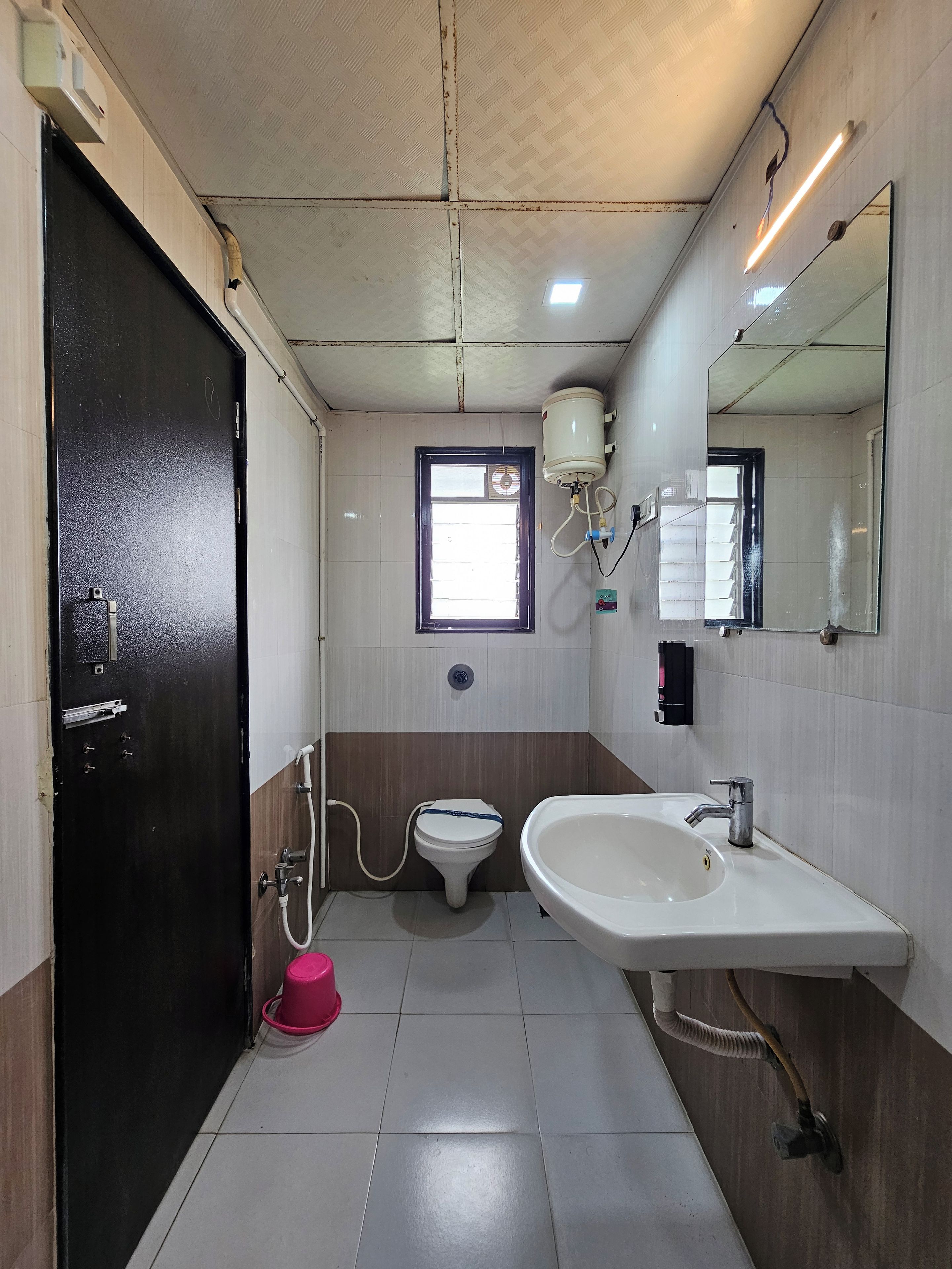 Un baño con inodoro, lavamanos y ventana.