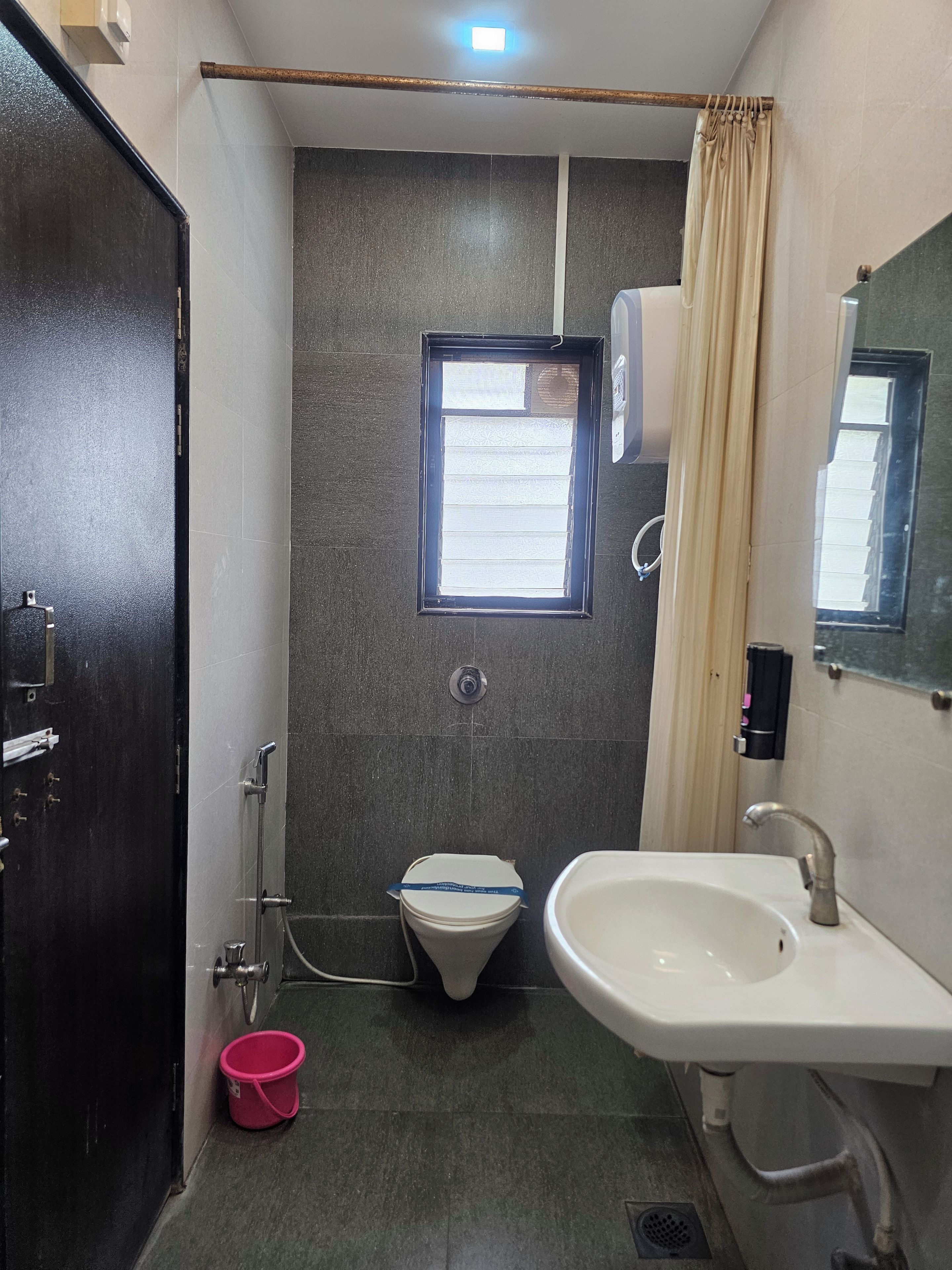 Un baño pequeño con inodoro, lavabo y ducha.