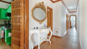 A hallway with a wooden door, a white console table, a gold-framed mirror, and green cabinets. - Vacation Chalet Isla Tenerife with Sea Views, Private Terrace and Wi-Fi (Tegueste)