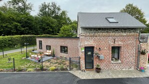 A brick building with a small porch, a door, and a window. - Le Gîte des Romains Country house (Anor)