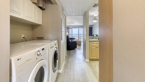 A laundry area with two LG washers, a kitchen with wooden cabinets, and a view to the outside. - Ormond Beach, Ocean View, Balcony, Beach Access (Ormond Beach)