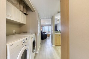 A laundry area with two LG washers, a kitchen with wooden cabinets, and a view to the outside. - Ormond Beach, Ocean View, Balcony, Beach Access (Ormond Beach)