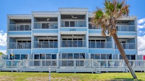 A multi-story hotel with balconies, a palm tree, and a clear sky. - Ormond Beach, Ocean View, Balcony, Beach Access (Ormond Beach)