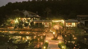 A riverside hotel with a pond, a bridge, and a pathway. - Double Room with Garden View (Hà Nội)