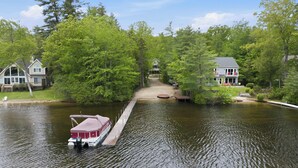 Un lago con un molo, una casa a sinistra e un'altra a destra.
