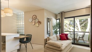 Een moderne woonkamer met een bank, een eettafel en een keukenhoek.