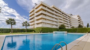 A modern multi-story hotel with a swimming pool, surrounded by well-maintained greenery and palm trees. - São Vicente - Vilamoura (Vilamoura)