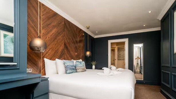 Ein Hotelzimmer mit einem großen Bett, einem Schreibtisch und einem Kleiderschrank.