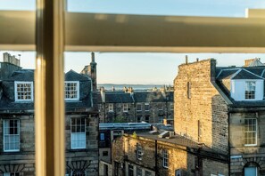 A view of a historic town with stone buildings, a prominent tower, and a clear sky. - Stylish Hideaway in Central Edinburgh - Pass the Keys (Edinburgh)