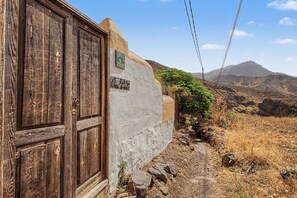 Un edificio rústico con una puerta de madera y un letrero que indica 'el Pueblo Casa de los Muertos'.