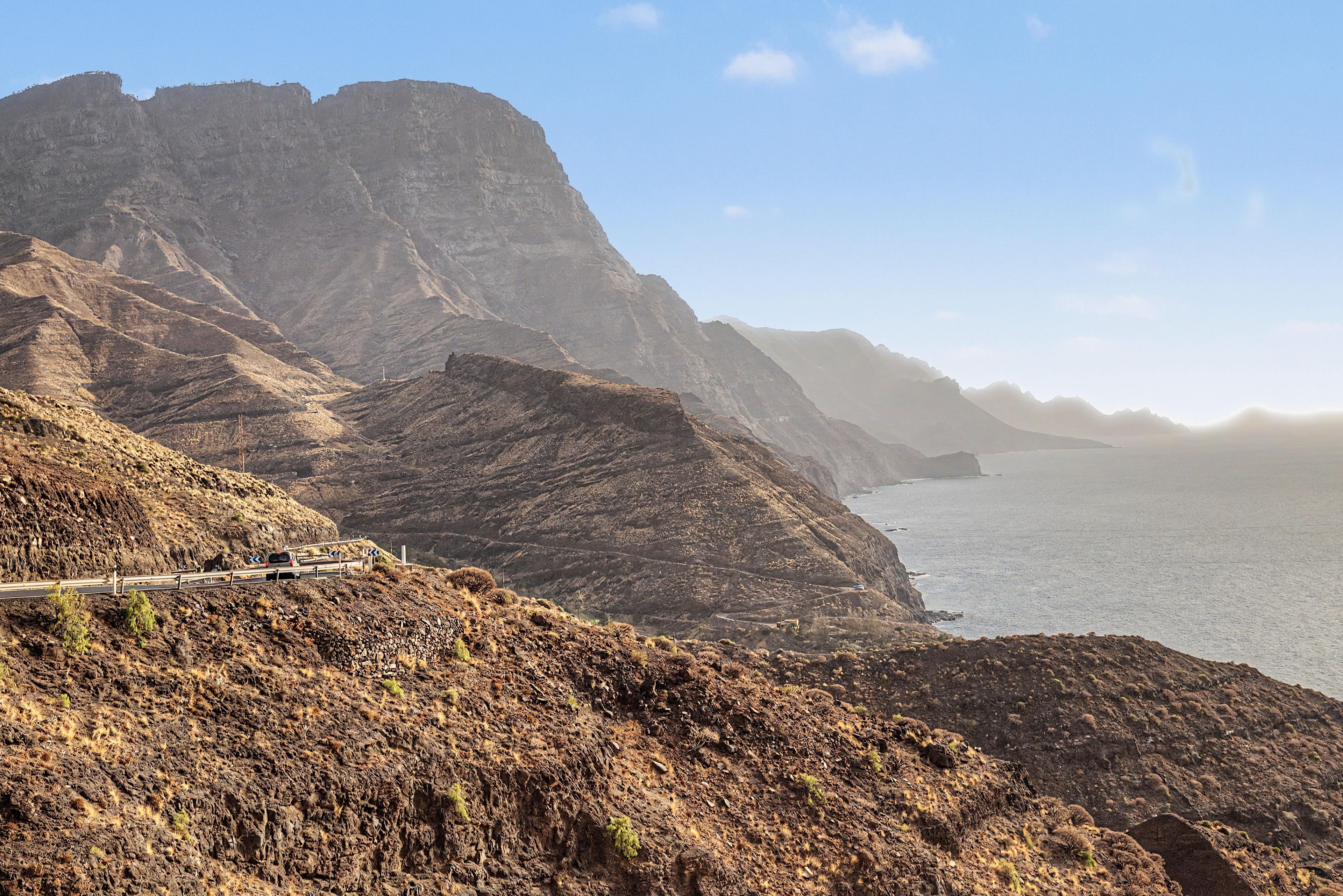 Una carretera costera con terreno rocoso y una vista despejada del mar.