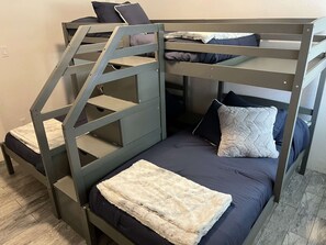 A bunk bed with a staircase, a white fluffy blanket, and dark blue bedding. - Giant Steps Unit 38 Ski in/ Ski out (Brian Head)